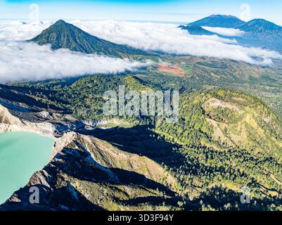 Aus der Vogelperspektive auf die Felsenklippe am Kawah Ijen Vulkan mit türkisfarbenem Schwefelwassersee bei Sonnenaufgang. Fantastischer Blick auf die Naturlandschaft in Ost-Java, Indonesien. Natu Stockfoto