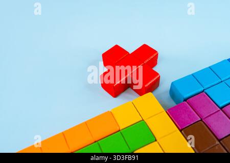 Geometrische Figuren verschiedener Farben auf blauem Hintergrund, das Konzept des abstrakten Denkens und der Logik. Katamino Game oder tetris. Stockfoto