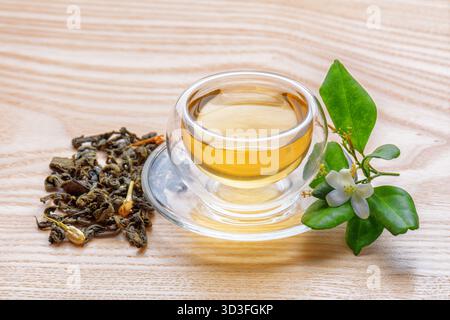 Grüner Jasmintee in klarer Tasse auf Holztisch Stockfoto
