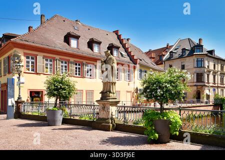 Ettlingen, Deutschland - 13. August 2025: Statue des Heiligen Johannes von Nepomuk auf der Rathausbrücke über die Alb mit Gebäuden in der Altstadt Stockfoto