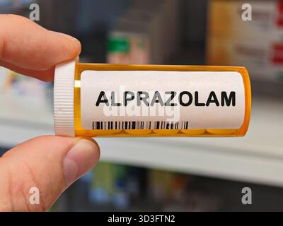 Orange Plastikbox ALPRAZOLAM Tabletten auf einem Krankenhaus Apothekentisch verwendet, um Angst und Panikstörungen ein Benzodiazepin zu behandeln. Apothekenlager Stockfoto