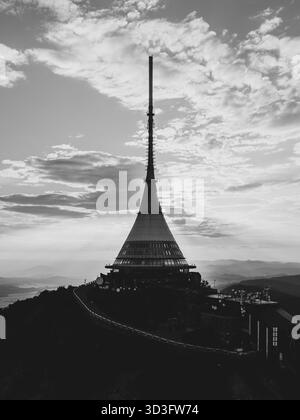 Das Jested Mountain Hotel erhebt sich vor einem atemberaubenden Sonnenuntergangshimmel in Liberec und zeigt seine moderne Architektur und seine markante Silhouette, während die Sonne über dem Horizont untergeht. Stockfoto