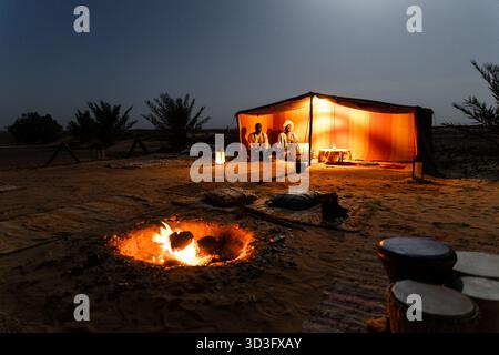 Eine ruhige Schönheit eines Wüstencamps in Merzouga, Marokko, wo Nomaden in traditionellen Berberzelten leben und das Wesen des nomadischen Lebens einfangen Stockfoto