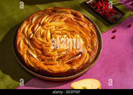Ein visuell atemberaubender hausgemachter Apfelkuchen, kunstvoll in einem spiralförmigen Muster angeordnet. Dieses köstliche Dessert wird von einem fesselnden Blick von oben aufgenommen und ist pro Person Stockfoto