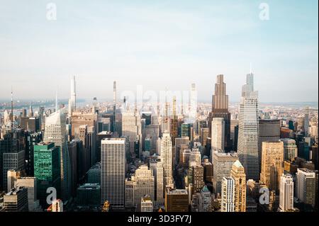 Aus der Vogelperspektive auf die berühmte Skyline von New York City bei Sonnenuntergang mit prominenten Wolkenkratzern wie dem Empire State Building und dem Chrysler Building und Stockfoto