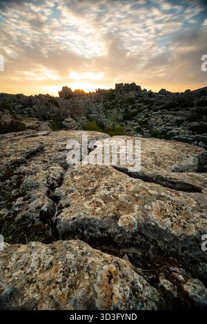 Atemberaubender nächtlicher Blick auf die Kalksteinformationen in El Torcal de Antequera mit dramatischen Texturen und Schatten unter dem Mondschein. Captu Stockfoto