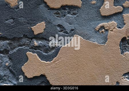 Nahaufnahme einer Wand mit strukturierten Oberflächen mit rauen braunen und grauen Flecken. Die kontrastierenden Farben erzeugen ein natürliches Muster mit haptischer Oberfläche Stockfoto
