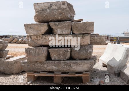 Die gestapelten Betonplatten sind auf einer Holzpalette auf einer belebten Baustelle ordentlich angeordnet und zeigen die wesentlichen Baumaterialien, die bei Mod verwendet werden Stockfoto