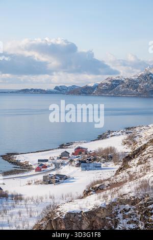 Panoramablick vom Grotfjord Point View in Norwegen mit schneebedeckten Häusern an den beschaulichen Fjorden. Das Gebiet ist von rauen, schneebedeckten Flächen umgeben Stockfoto
