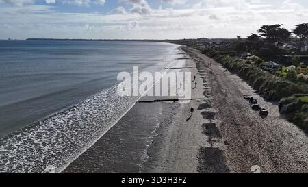 Wexford, Irland - 28. Oktober 2025 - die Menschen spazieren am Strand von Rosslare entlang, während die Sonne im County Wexford langangeht Stockfoto