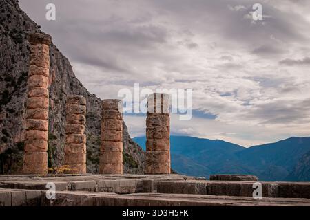 Die Säulen, die vom antiken Tempel in Delphi am steilen Unterhang des Parnassos erhalten sind. Stockfoto
