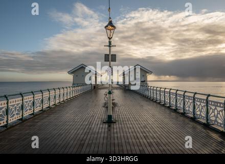 Penarth Pier in South Wales, Großbritannien, am zweiten Weihnachtsfeiertag mit der Sonne hinter den Wolken und der Pier-Lampe Stockfoto