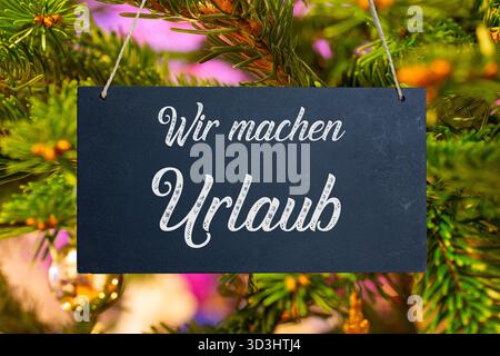(Fotomontage) Firmenfeiertage zu Weihnachten: Schild mit der Aufschrift wir MACHEN URLAUB vor einem Weihnachtsbaum Stockfoto
