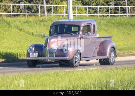 Calgary, Alberta, Kanada. Juni 2025. Ein wunderschön restaurierter Vintage Ford Pickup, ein Modell aus den 1940er Jahren, glänzt mit klassischem Charme, während er auf einem Griee entlang fährt Stockfoto
