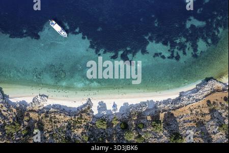 Türkisfarbenes Wasser liegt sanft an einem abgeschiedenen Strand, an dem Touristen im Sommer Sonnenbaden und Schwimmen genießen. Tropischer Strand Kefalonia griechische Inseln Stockfoto