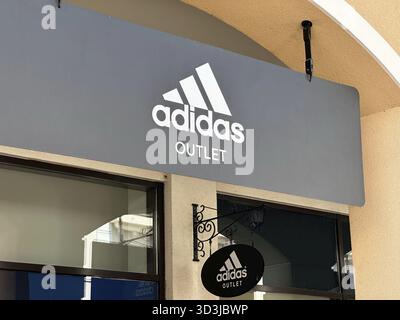 Belgrad, Serbien - 16. Juni 2024: Außenbeschilderung der Ladenfront von Adidas Outlet mit dem berühmten Logo und Branding in drei Streifen Stockfoto