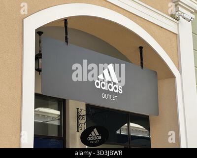Belgrad, Serbien - 16. Juni 2024: Außenbeschilderung der Ladenfront von Adidas Outlet mit dem berühmten Logo und Branding in drei Streifen Stockfoto