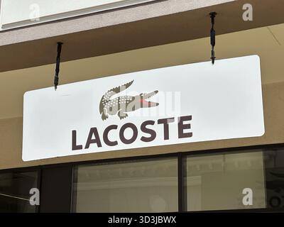 Belgrad, Serbien - 16. Juni 2024: Nahaufnahme des Lacoste-Logos mit einem Krokodil auf einem Ladenschild, einem bekannten Symbol in der Modebranche Stockfoto