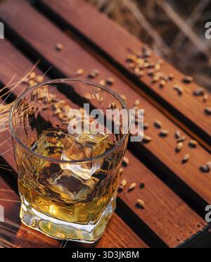 Essen, Ein Glas Whiskey auf einem Weizenfeld Stockfoto