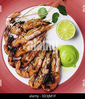 Speisen, gegrillte Tigergarnelen oder Garnelen auf rotem Teller Stockfoto