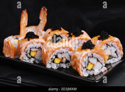 Essen, Sushi-Brötchen mit gebratenem Lachs, Garnelen und schwarzem Kaviar Stockfoto