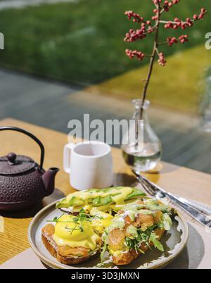 Essen, Eier benedict auf englischem Muffin mit geräuchertem Lachs, Salatmischung und Hollandaise-Sauce Stockfoto