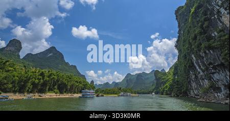 Yangshuo, China - August 2019 : Panoramablick auf das Sightseeing-Boot mit Touristen Segeln zwischen atemberaubenden Karst Berglandschaft auf dem herrlichen Stockfoto