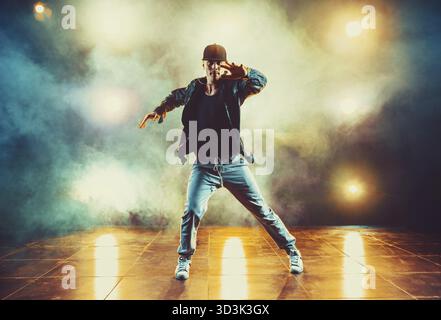 Junger Mann pause Tanzen im Club mit Licht und Rauch Stockfoto