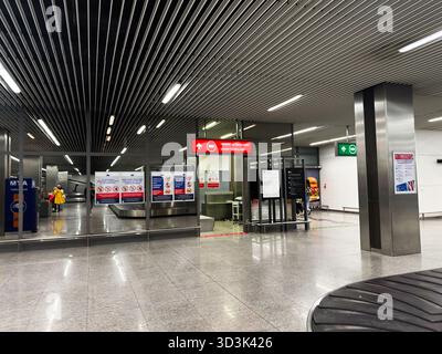 Balice, Polen - 4. Oktober 2025: Geräumige Sicherheitszone des Flughafens Krakau mit Schildern, Reisenden und Glastüren in einem modernen Terminal. Stockfoto