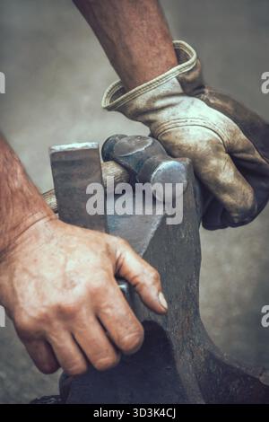 Ein Schmied seine Hände nach der Arbeit bei fairen Mittelalterfest in Streatham Park in London auf Amboss ruht Stockfoto