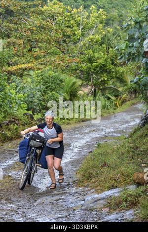 Radfahrer mit Fahrrad schwer Dschungel Weg in Richtung Mananara entlang der Vanille in Madagaskar zu kämpfen Stockfoto