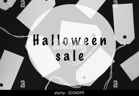 Halloween-Verkaufsanhänger sind auf einem dunklen Hintergrund verstreut und mit einem runden Designelement versehen, das die festliche Atmosphäre unterstreicht, perfekt zum Markieren Stockfoto
