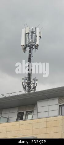 Berlin, Deutschland - 27. Juni 2025: . Der Mobilfunkturm ist auf einem Gebäude unter bewölktem Himmel montiert Stockfoto