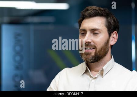 Ein Nahfoto eines jungen Mannes, der an seinem Arbeitsplatz sitzt, die Augen geschlossen, ruht und träumt. Stockfoto