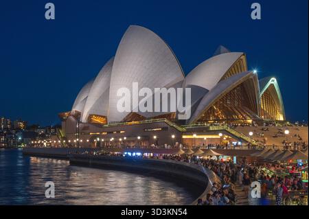Sydney Opera House (entworfen von Jorn Utzon) beleuchtet bei Nacht vom Ufer des Circular Quay, Sydney, New South Wales, Australien. Stockfoto