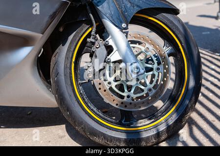 Das Vorderrad eines leistungsstarken Sportmotorrads mit Bremsanlage und Gabel. Stockfoto