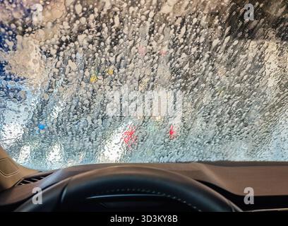Nahaufnahme der automatischen Waschanlage. POV-Ansicht aus dem Inneren eines Autos bei einer Tunnelwaschanlage Stockfoto