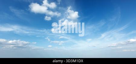 Ein ruhiger Himmel mit weichen Wolken unter hellblauen Tönen schafft eine ruhige Tagesszene, ideal zum Entspannen und Reflektieren. Stockfoto