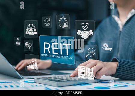 REIT Real Estate Investment Trust-Konzept. Person, die ein Notebook mit REIT-Symbolen verwendet, die Immobilieninvestitionen, Finanzwachstum, Immobilien, Vermögenswerte, Stockfoto
