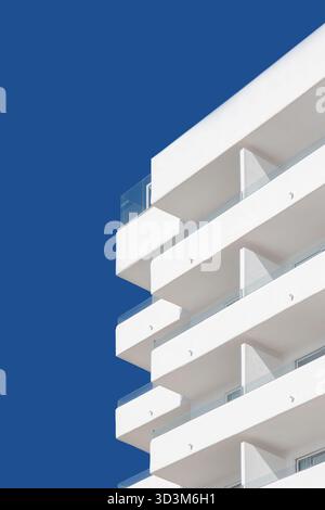 Modernes Apartmentgebäude mit sich wiederholenden Balkonen und Glasgeländern vor blauem Himmel abstrakt, geometrische Muster, Can pastilla, mallorca, spanien Stockfoto