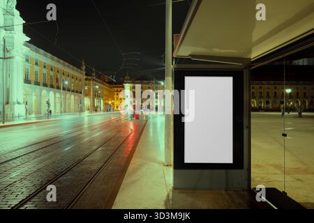 Leere vertikale Reklametafeln an der Straßenbahnhaltestelle auf dem beleuchteten Stadtplatz bei Nacht, perfekt für Außenwerbung, Marketing-Design oder städtisches Branding Stockfoto