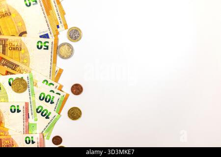 Verschiedene Euro-Banknoten und -Münzen sind auf einem einfachen Hintergrund angeordnet, wobei verschiedene Stückelungen in einem geordneten Layout dargestellt werden und die Währung betont wird Stockfoto