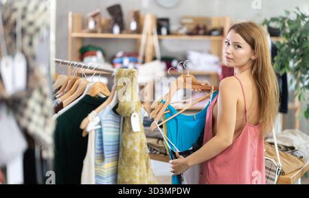 Die Frau wählt Kleidung aus der Sommerkollektion Stockfoto