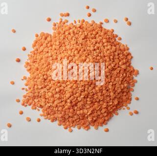 Haufen roter Linsen, Masoor dal Pulses mit einem leuchtenden orange-roten Farbe isolierten weißen Hintergrund, Konzepte von gesunden Inhaltsstoffen und veganem Protein Stockfoto