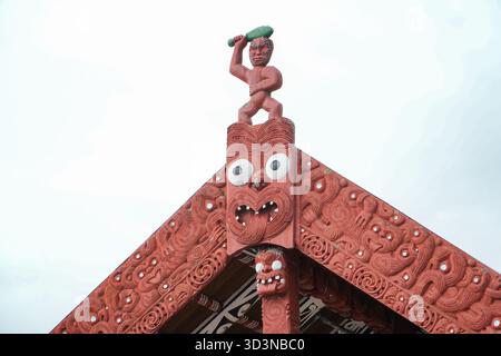 Maori-Schnitzerei auf einem Dach des traditionellen Versammlungshauses (Wharenui) mit komplizierten Designs und Figuren in Whakarewarewa, dem lebenden Maori-Dorf, Rotorua, Stockfoto