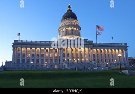 Utah State Capitol beleuchtet in der Abenddämmerung mit grünem Gras im Vordergrund Stockfoto
