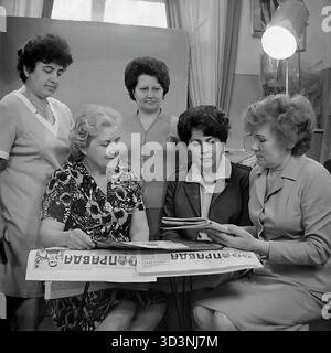 Ein Archivfoto aus dem Jahr 1981 zeigt ein Treffen des Frauenrates (Zhensovet) in der AIZ (Armature-Isolator Plant) in Sloviansk, Ukrainische SSR. Fünf weibliche Angestellte versammeln sich in einem Büro zu einer politischen Diskussion. Sie sitzen um einen Tisch, der mit Kopien der "Prawda", der offiziellen Zeitung der Kommunistischen Partei, bedeckt ist. Die Frauen lesen und diskutieren die Artikel. Diese Szene fängt die Mischung aus sozialer und ideologischer Arbeit innerhalb einer sowjetischen Fabrik ein. Dies zeigt den Alltag im friedlichen Donbass vor dem Krieg. Stockfoto