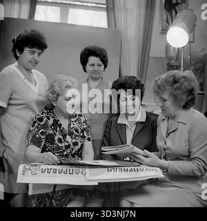 Ein Archivfoto aus dem Jahr 1981 zeigt ein Treffen des Frauenrates (Zhensovet) in der AIZ (Armature-Isolator Plant) in Sloviansk, Ukrainische SSR. Fünf weibliche Angestellte versammeln sich in einem Büro zu einer politischen Diskussion. Sie sitzen um einen Tisch, der mit Kopien der "Prawda", der offiziellen Zeitung der Kommunistischen Partei, bedeckt ist. Die Frauen lesen und diskutieren die Artikel. Diese Szene fängt die Mischung aus sozialer und ideologischer Arbeit innerhalb einer sowjetischen Fabrik ein. Dies zeigt den Alltag im friedlichen Donbass vor dem Krieg. Stockfoto