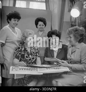 Ein Archivfoto aus dem Jahr 1981 zeigt ein Treffen des Frauenrates (Zhensovet) in der AIZ (Armature-Isolator Plant) in Sloviansk, Ukrainische SSR. Fünf weibliche Angestellte versammeln sich in einem Büro zu einer politischen Diskussion. Sie sitzen um einen Tisch, der mit Kopien der "Prawda", der offiziellen Zeitung der Kommunistischen Partei, bedeckt ist. Die Frauen lesen und diskutieren die Artikel. Diese Szene fängt die Mischung aus sozialer und ideologischer Arbeit innerhalb einer sowjetischen Fabrik ein. Dies zeigt den Alltag im friedlichen Donbass vor dem Krieg. Stockfoto