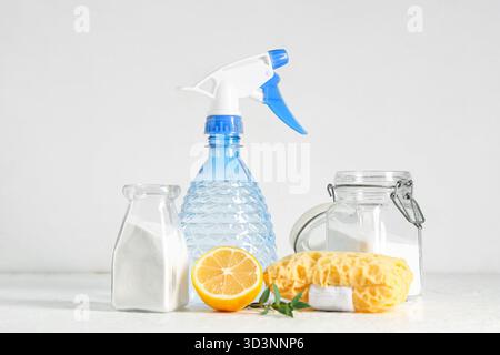 Backnatron mit Essig, Zitrone und Reinigungsschwamm auf weißem Grunge-Hintergrund Stockfoto